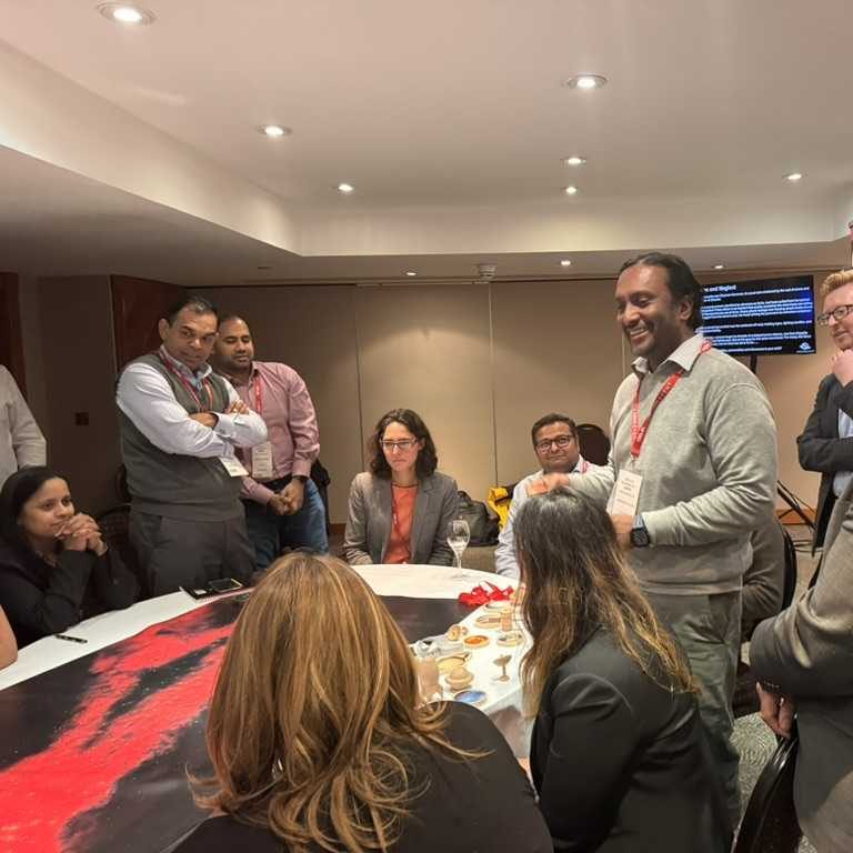 C-suite members participating in a SOE, gathered around a table thinking and discussing a star map and artifacts on the table before them.