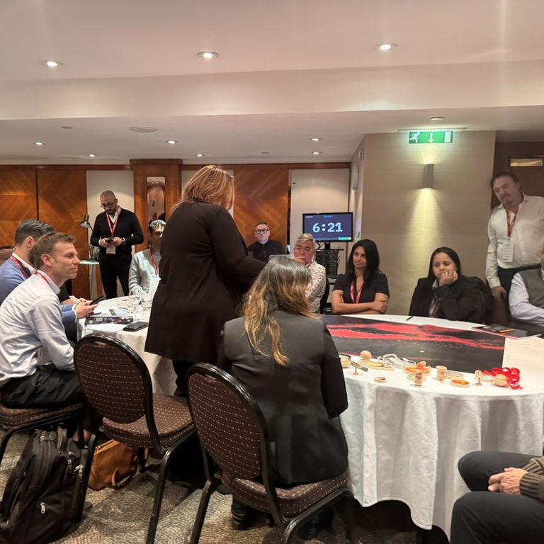 C-suite members participating in a SOE, gathered around a table thinking and discussing a star map and artifacts on the table before them.